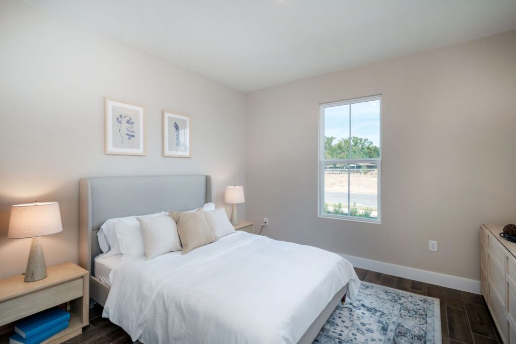 Guest bedroom in the Palomino model at Sabana Reserve with neutral walls, modern furniture, and natural light.